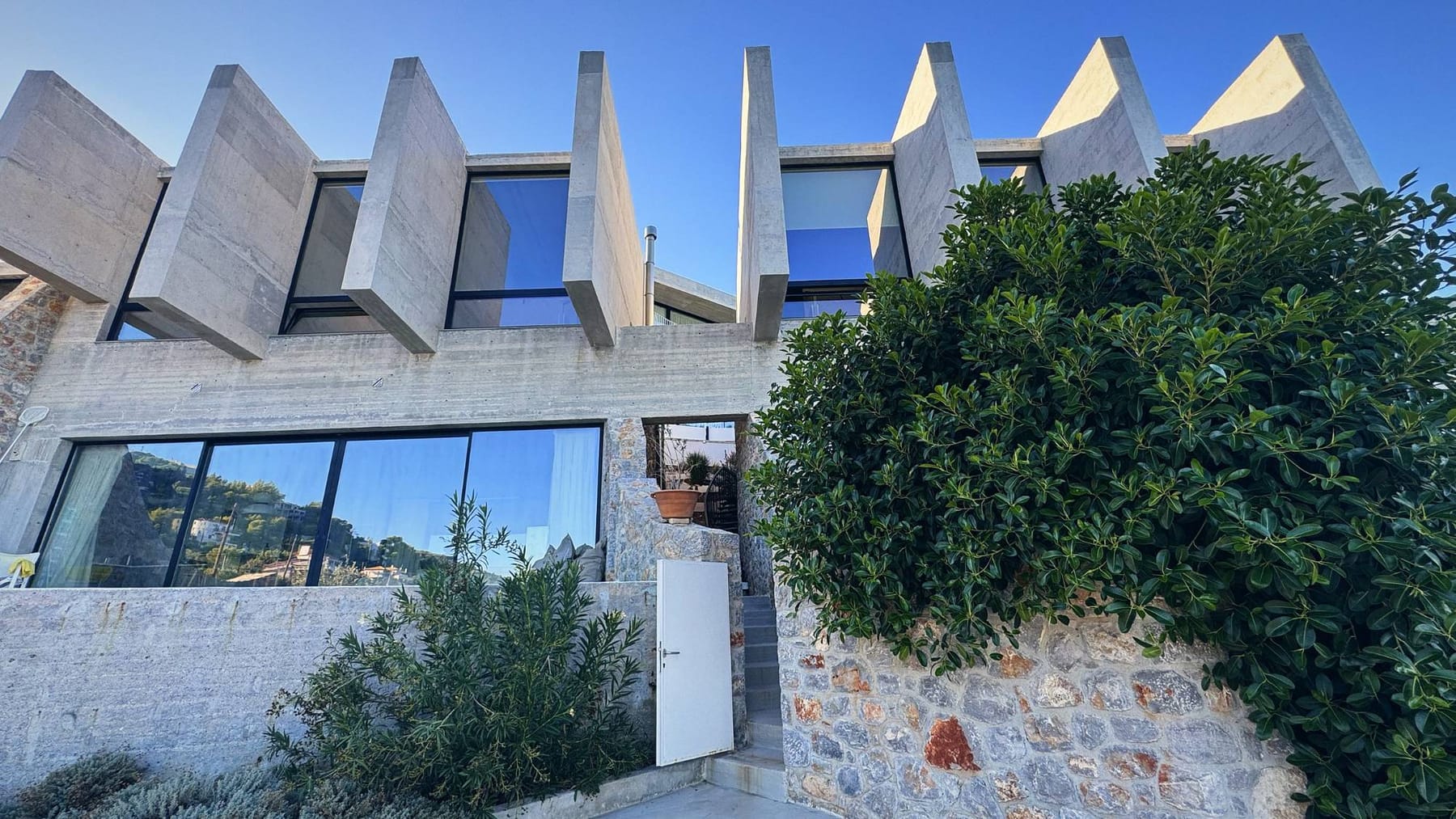 Κατοικίες από πέτρα και εμφανές σκυρόδεμα στο Αμόνι Κορινθίας, έργο της κατασκευαστικής εταιρείας Αφοί Πλεπαράκου
